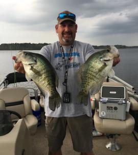 Image of fishing guide holding two fresh caught largemouth bass